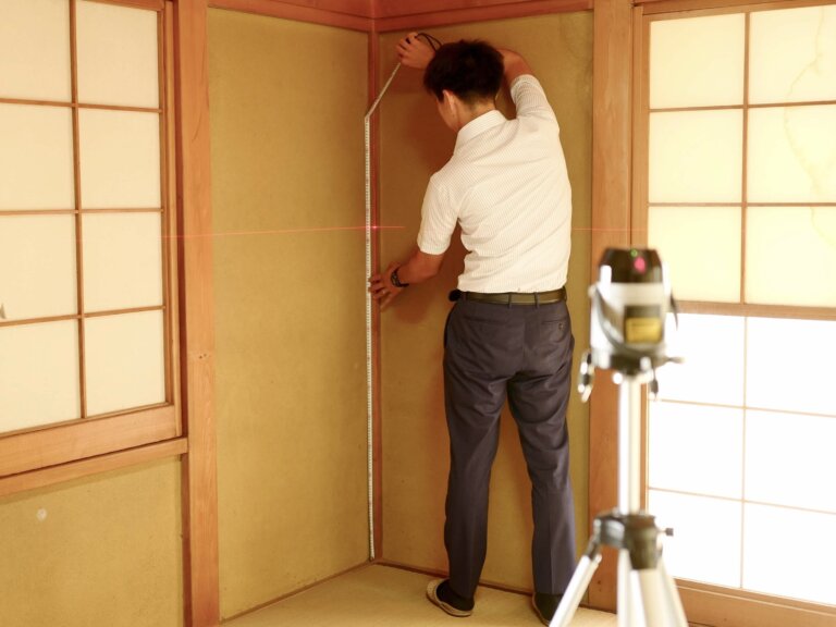 建物の傾きをレーザーの機器で測る調査の様子