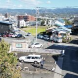 三島市青木エリアの住宅街の風景｜住宅やマンション、駐車場が並び、背景に山々が広がる街並み